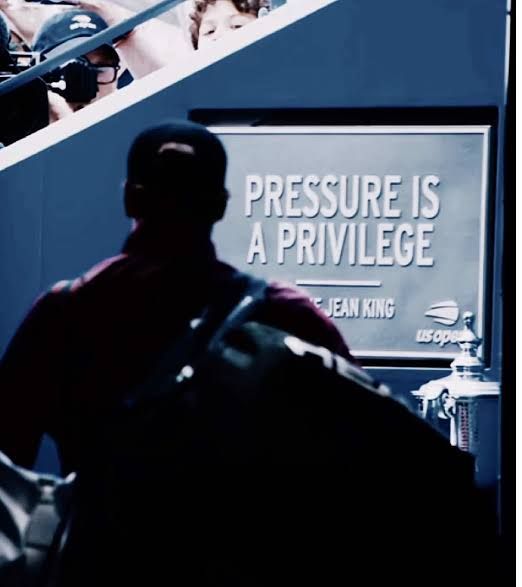 A player walks past the 'Pressure is a privilege' sign in the US Open players' tunnel